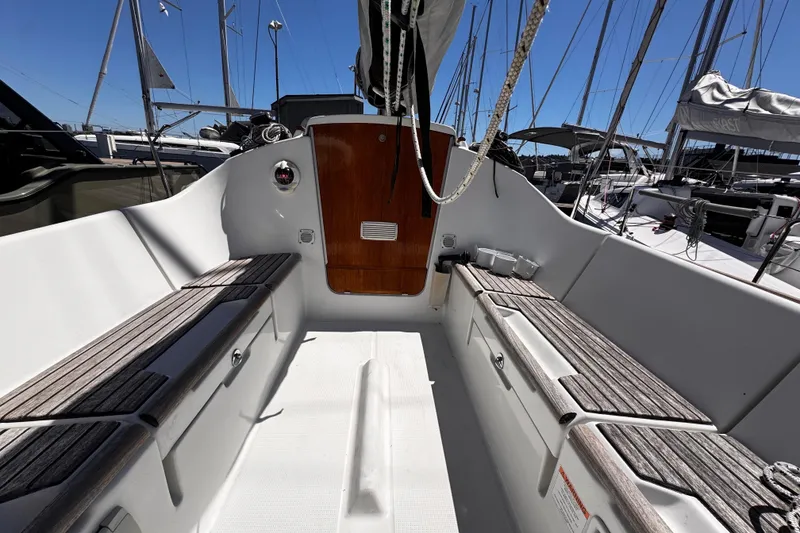 Slide: The Image of 2014 Beneteau FIRST 25 S sailboat cockpit with wooden benches and sleek design. - 14