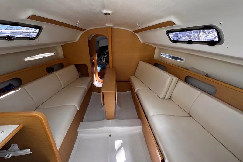 Slide: The Image of Interior of 2014 Beneteau FIRST 25 S sailboat with beige seating and wooden accents. - 23