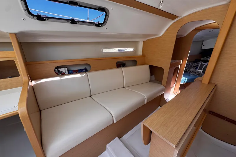 Slide: The Image of Interior of 2014 Beneteau FIRST 25 S sailboat with beige seating and wooden accents. - 24