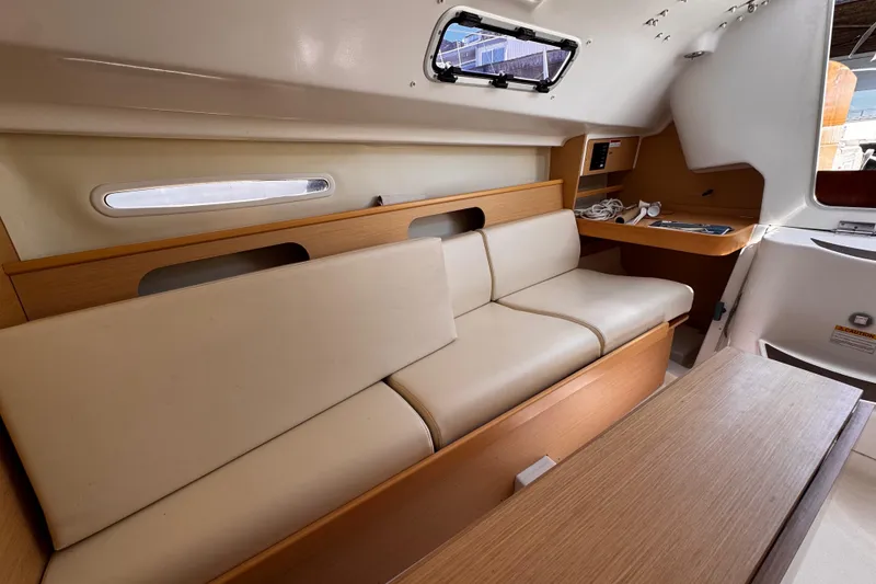 Slide: The Image of Interior of 2014 Beneteau FIRST 25 S sailboat with beige seating and wooden accents. - 25