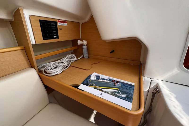 Slide: The Image of Interior of 2014 Beneteau FIRST 25 S sailboat with control panel and brochure. - 27