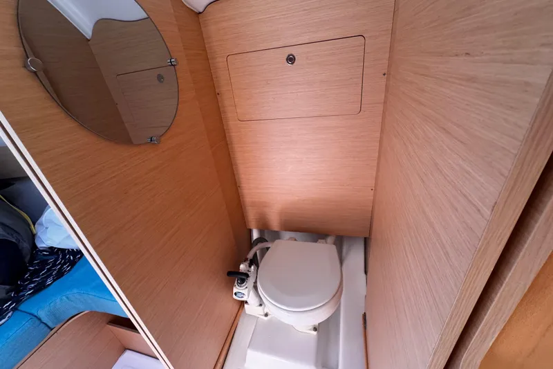 Slide: The Image of Compact bathroom in 2014 Beneteau FIRST 25 S sailboat with wooden paneling and marine toilet. - 28