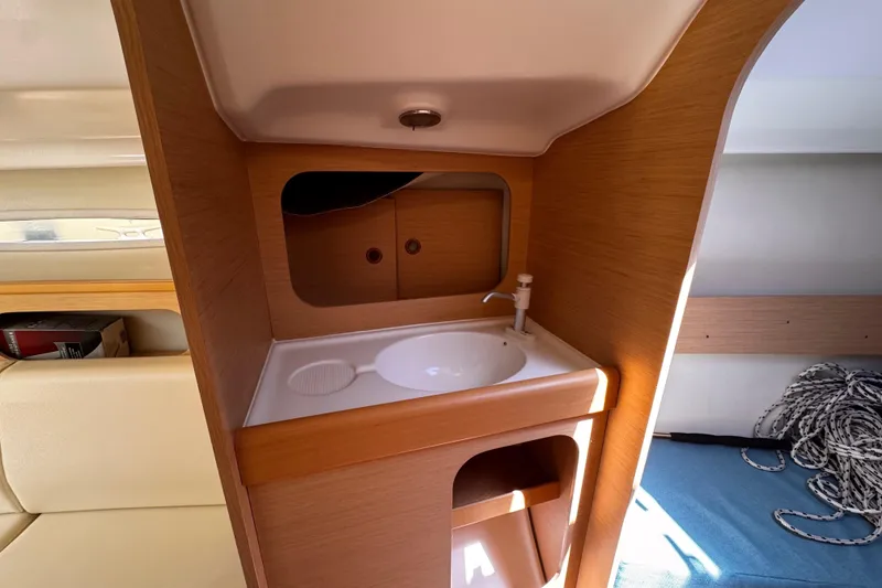 Slide: The Image of Interior of 2014 Beneteau FIRST 25 S sailboat featuring compact sink and storage area. - 29