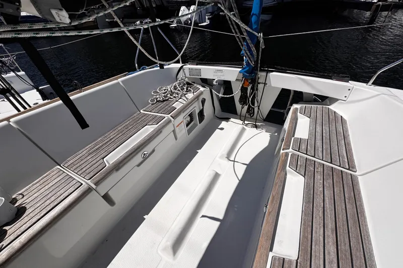 Slide: The Image of 2014 Beneteau FIRST 25 S sailboat cockpit with wooden seating and nautical ropes. - 34