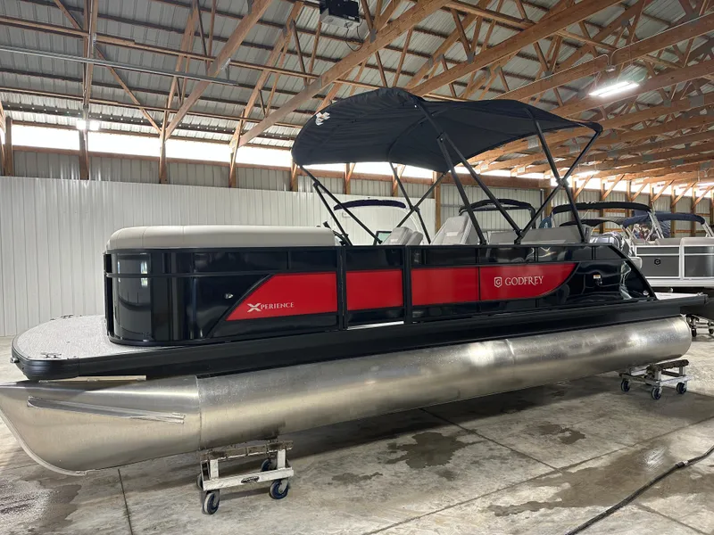 The Image of 2025 Godfrey Xperience Lounge pontoon boat in a warehouse setting. - 1