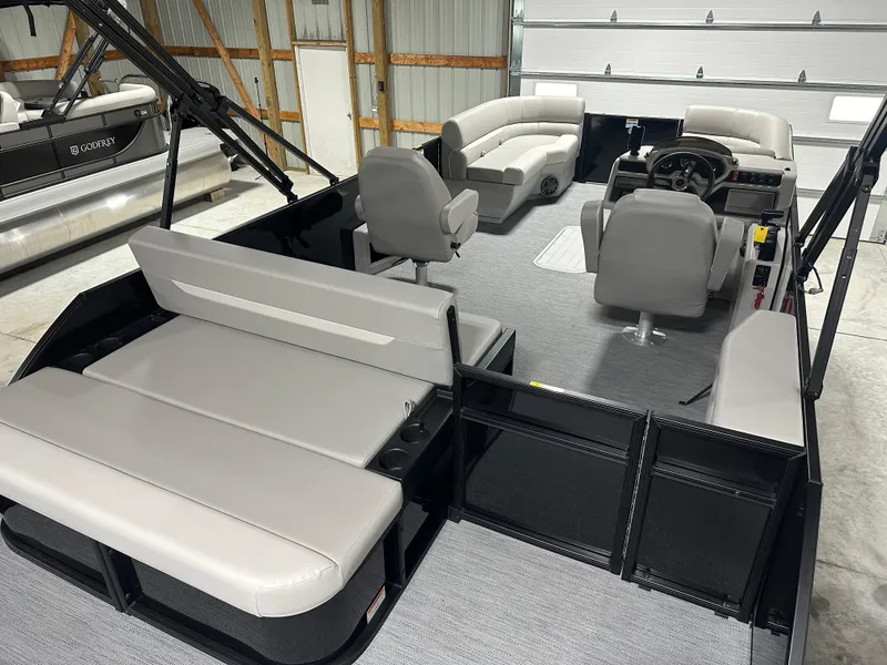 Slide: The Image of 2025 Godfrey Xperience Lounge boat interior with modern seating and steering console. - 7