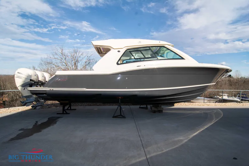 The Image of 2022 Scout 350 LXZ boat on display, side view, outdoors, under a blue sky. - 1