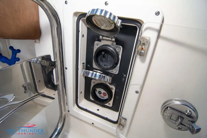 Slide: The Image of 2022 Scout 350 LXZ boat power outlet with protective cover and stainless steel trim. - 14