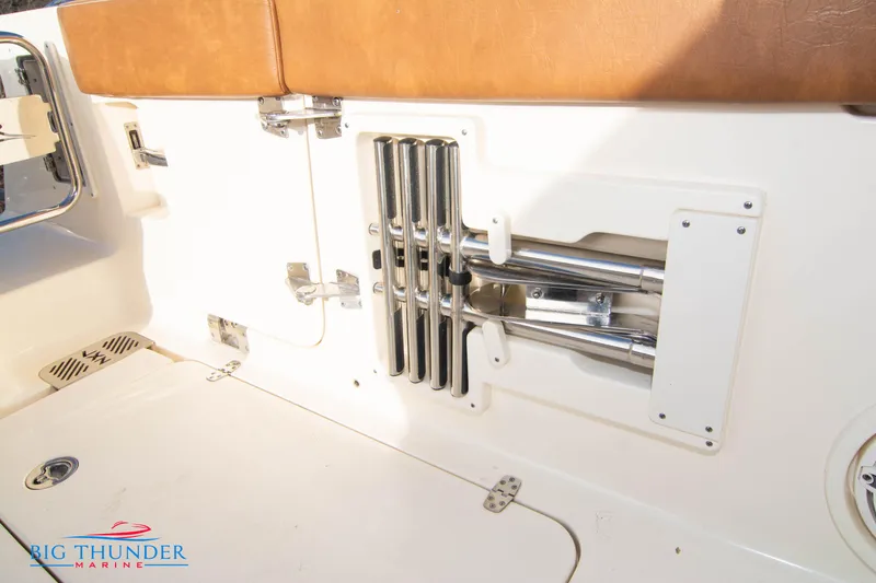 Slide: The Image of 2022 Scout 350 LXZ boat interior with stainless steel rod holders and tan seating. - 26