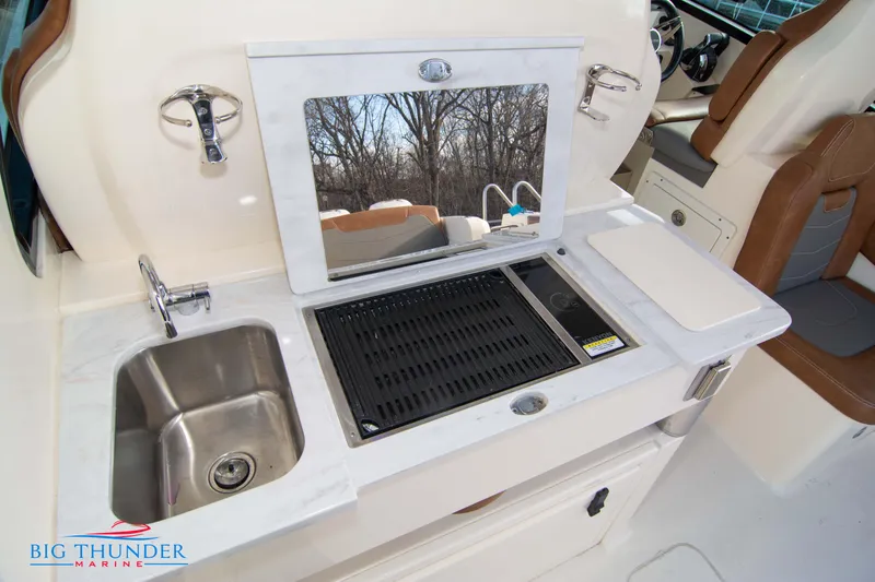 Slide: The Image of 2022 Scout 350 LXZ boat kitchenette with sink, grill, and countertop. - 31
