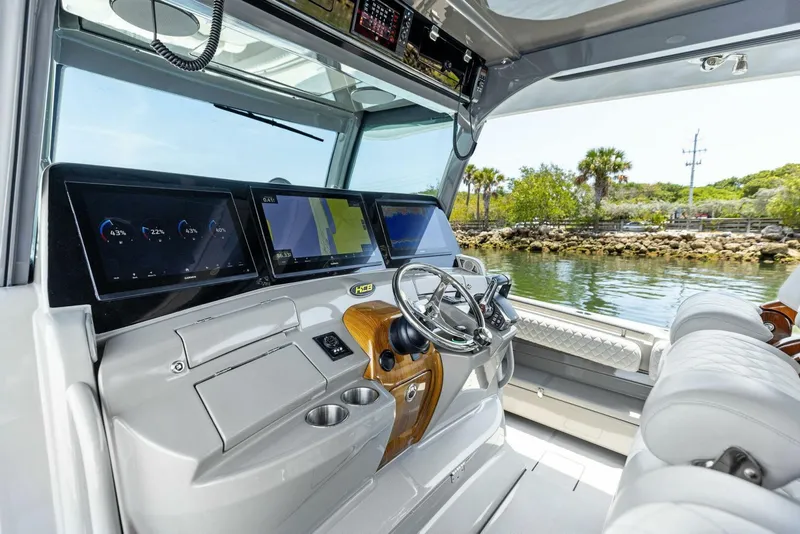 Slide: The Image of 2023 HCB 53 Sueños boat cockpit with advanced navigation displays and luxurious seating. - 11