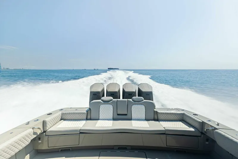Slide: The Image of 2023 HCB 53 Sueños boat cruising on open water, showcasing powerful engines and luxurious seating. - 23