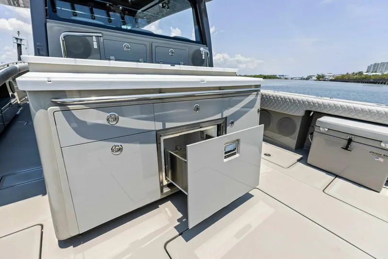 Slide: The Image of 2023 HCB 53 Sueños boat interior with open storage compartment, sleek design, and waterfront view. - 26