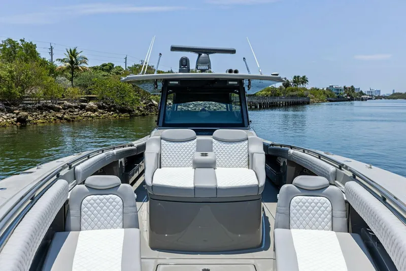 Slide: The Image of 2023 HCB 53 Sueños luxury boat with spacious seating on a calm waterway. - 3