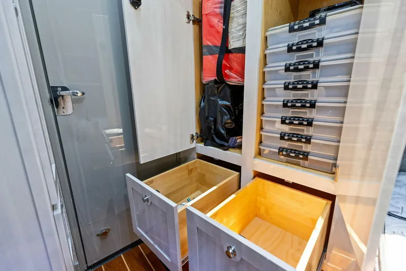 Slide: The Image of Storage compartments in 2023 HCB 53 Sueños boat, featuring drawers and organized shelves. - 33