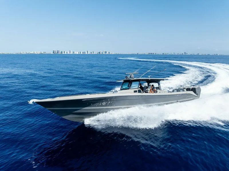 Slide: The Image of HCB 53 Sueños 2023 cruising on open ocean with city skyline in background. - 35