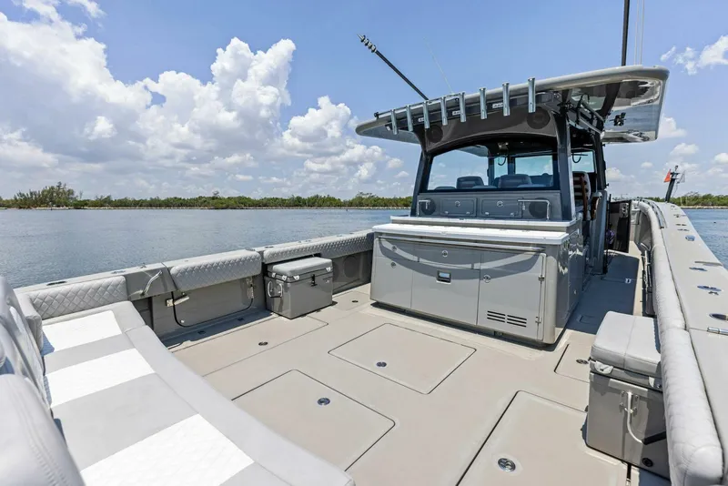 Slide: The Image of 2023 HCB 53 Sueños boat with spacious deck and seating, under a clear blue sky. - 5