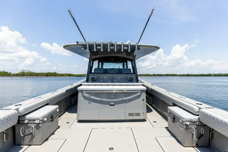 Slide: The Image of 2023 HCB 53 Sueños boat deck with seating and storage, on calm water under a clear sky. - 7