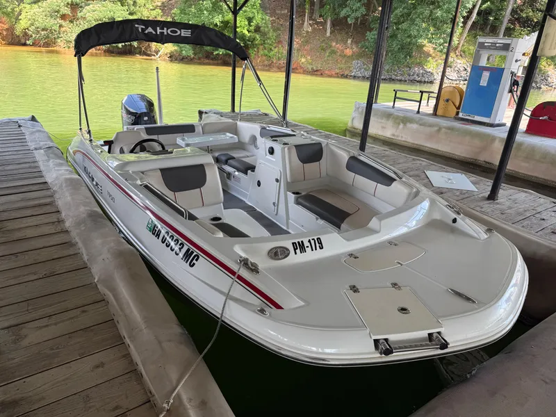 Slide: The Image of Tahoe 1950 boat, 2021 model, docked on a lake with green water and trees. - 13