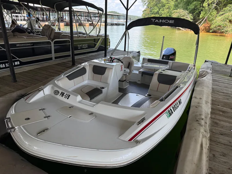 Slide: The Image of Tahoe 1950 boat docked on a lake, 2021 model, with canopy and seating. - 14