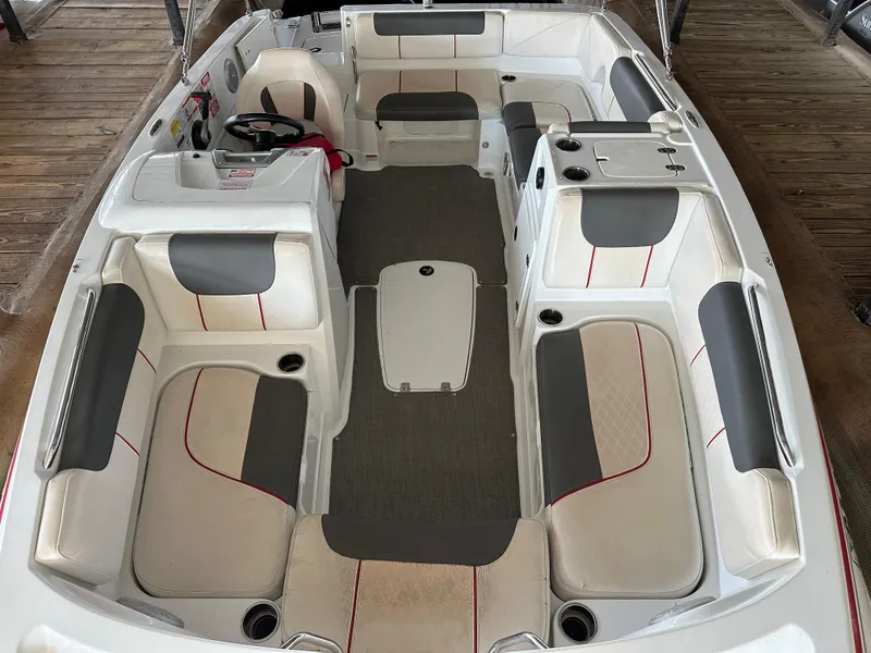 Slide: The Image of 2021 Tahoe 1950 boat interior with gray and white seating, red accents, and steering wheel. - 3