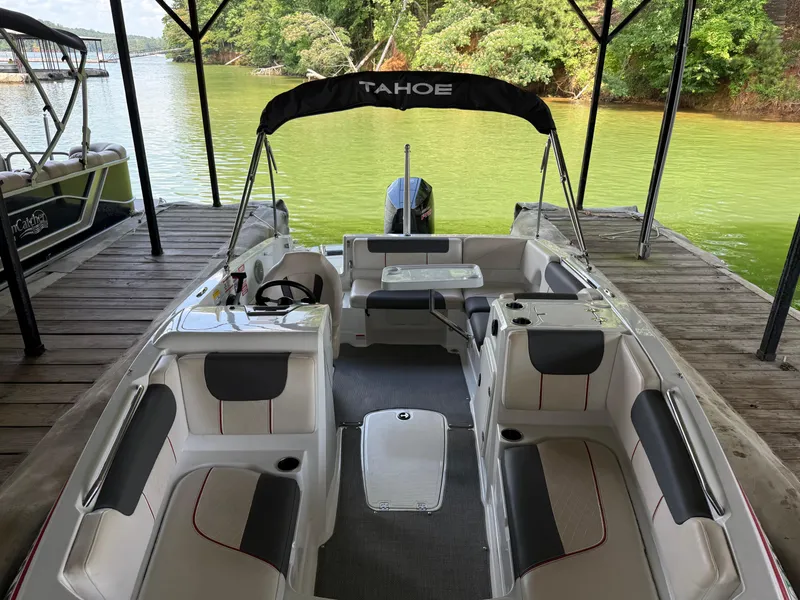 Slide: The Image of 2021 Tahoe 1950 boat docked on a serene lake with lush greenery. - 9