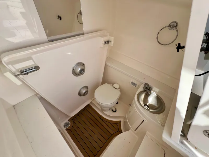 Slide: The Image of 2015 Intrepid 375 Center Console bathroom with toilet, sink, and wooden floor mat. - 9