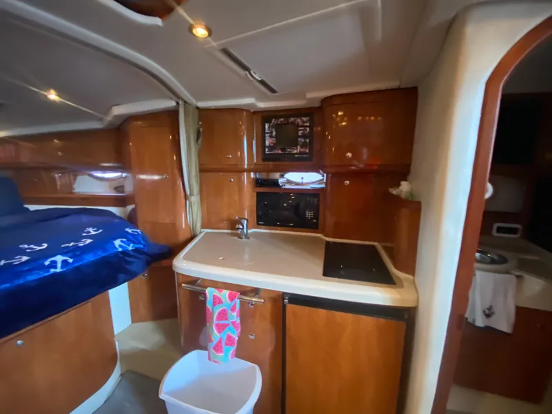 Slide: The Image of 2005 Four Winns 348 Vista yacht interior with kitchenette and cozy sleeping area. - 21