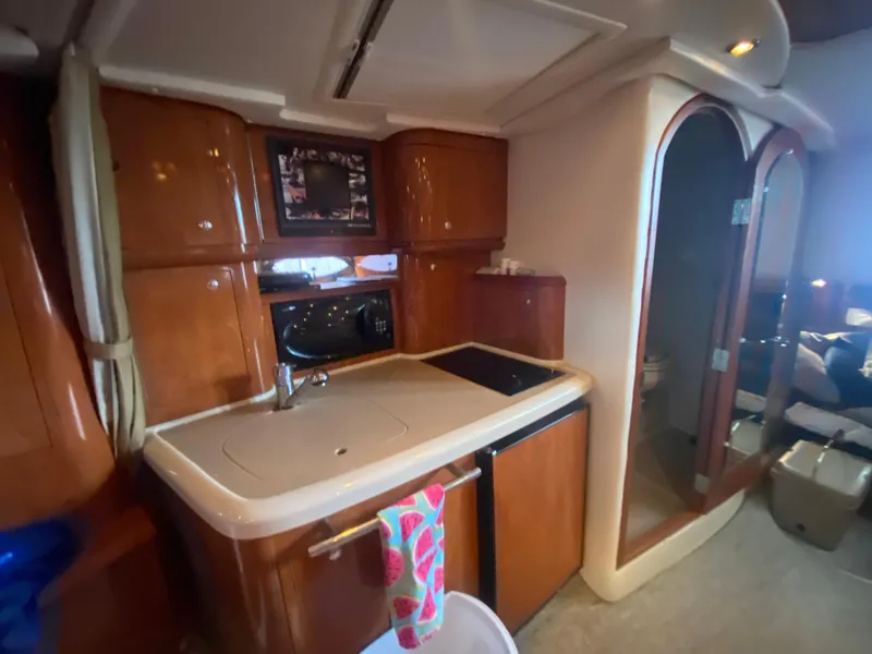 Slide: The Image of 2005 Four Winns 348 Vista yacht interior with kitchenette and wooden cabinetry. - 22