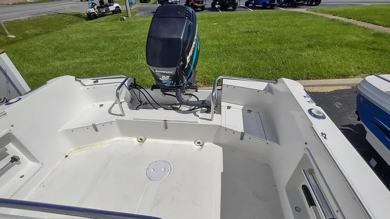 Slide: The Image of Robalo 2020 Center Console boat, 2001 model, with outboard motor, parked on grass. - 11