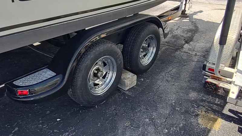 Slide: The Image of Trailer wheels of a 2001 Robalo 2020 Center Console boat on pavement. - 12