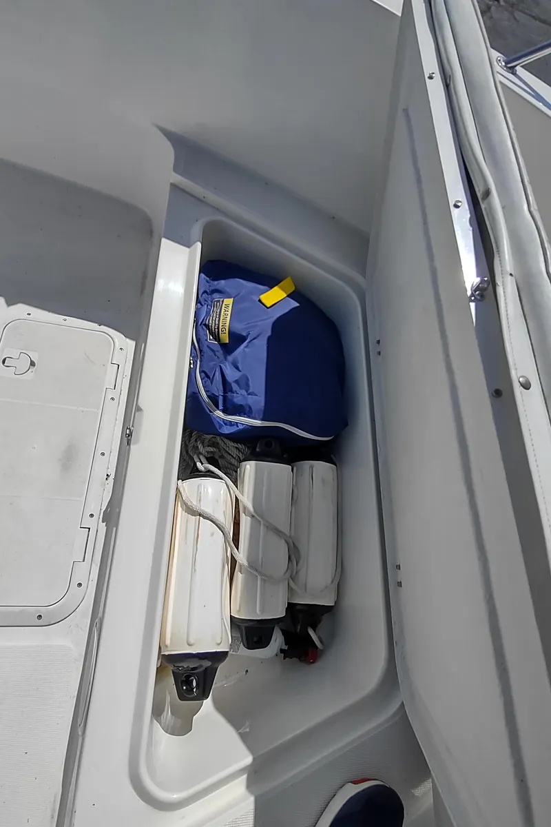 Slide: The Image of Storage compartment in a 2001 Robalo Center Console boat with life jackets and fenders. - 20