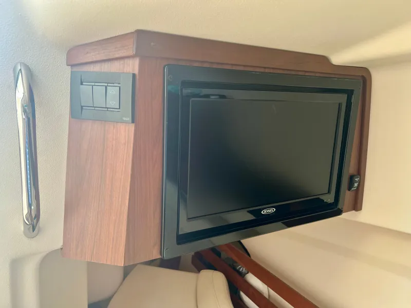 Slide: The Image of 2021 Grady-White Freedom 375 cabin with mounted TV and wooden paneling. - 24