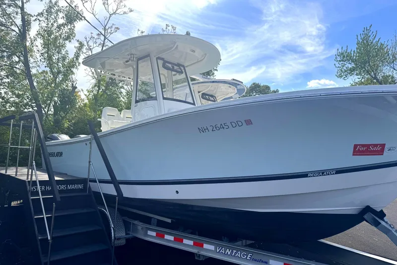 Slide: The Image of 2021 Regulator 25 boat on trailer, for sale, under clear blue sky. - 4