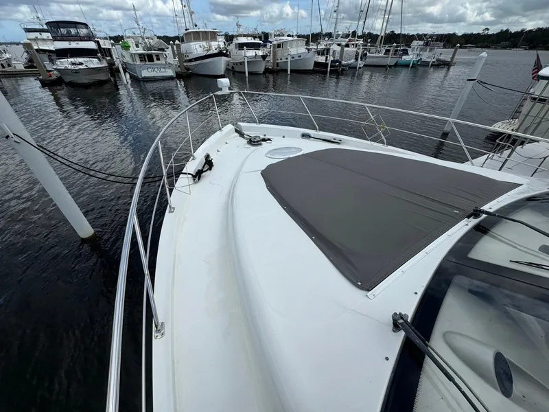 Slide: The Image of 2006 Carver 56 Voyager yacht docked at marina, surrounded by other boats. - 13