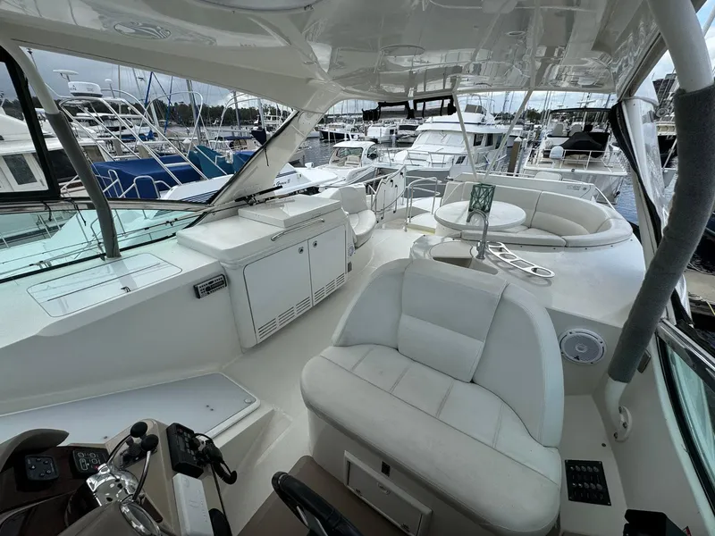 Slide: The Image of 2006 Carver 56 Voyager yacht interior with white seating and control panel at marina. - 20