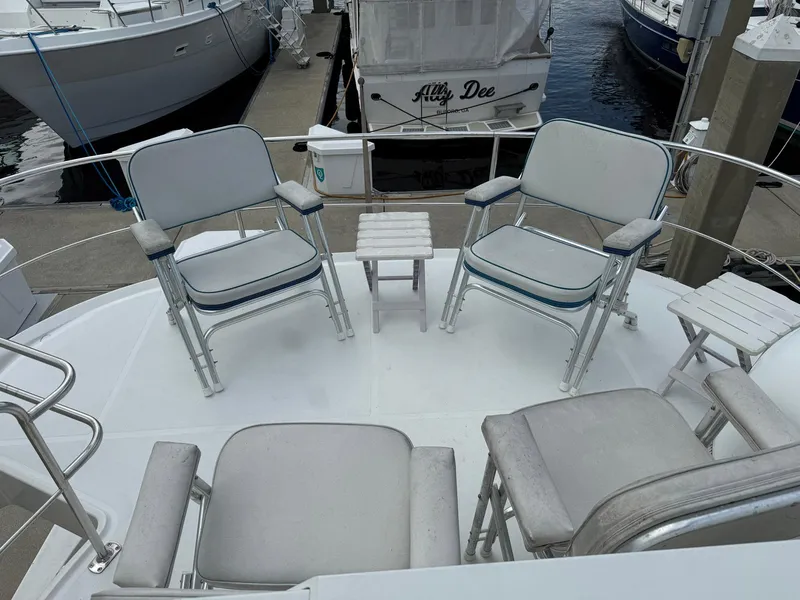 Slide: The Image of 2006 Carver 56 Voyager yacht deck with chairs and small tables at marina. - 22