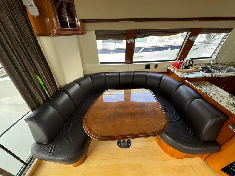 Slide: The Image of Luxurious 2006 Carver 56 Voyager yacht interior with curved leather seating and wooden table. - 28