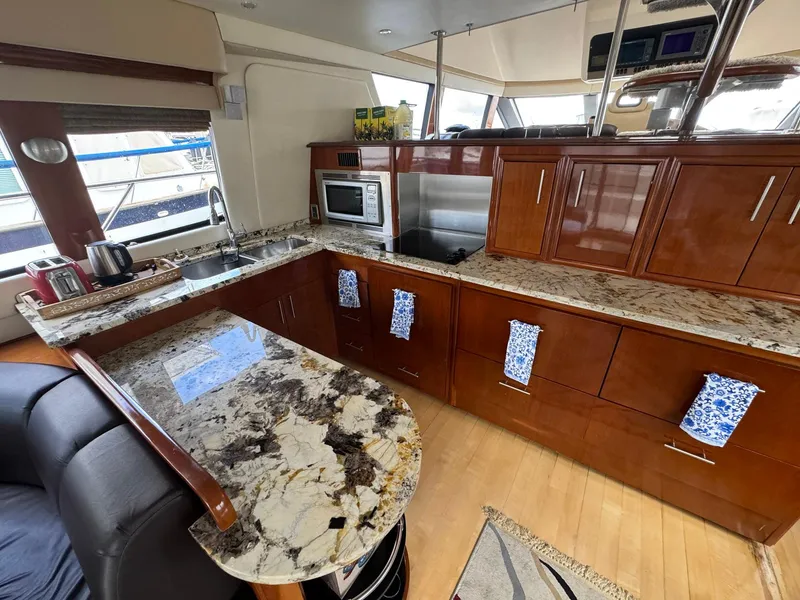 Slide: The Image of Luxurious kitchen in 2006 Carver 56 Voyager yacht with granite countertops and modern appliances. - 30