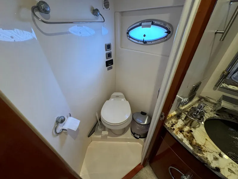 Slide: The Image of 2006 Carver 56 Voyager yacht bathroom with toilet, sink, and porthole window. - 45
