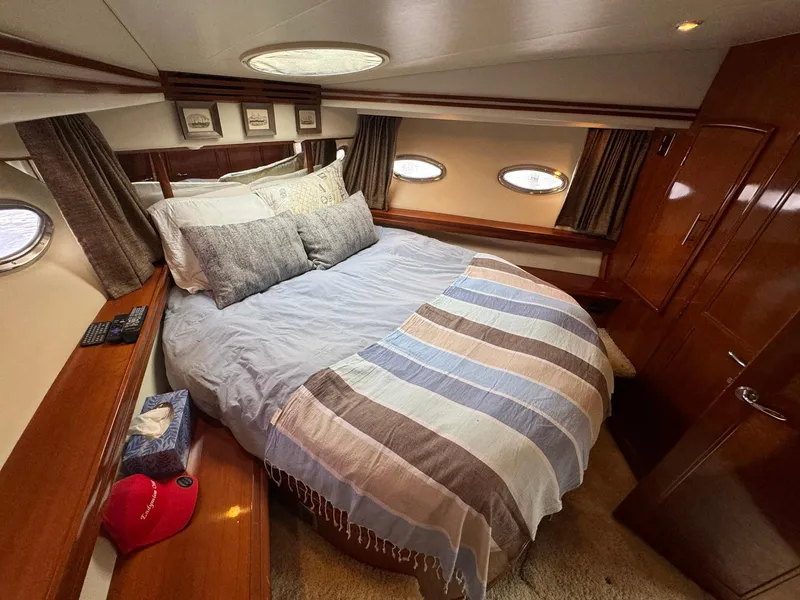 Slide: The Image of Luxurious bedroom interior of 2006 Carver 56 Voyager yacht with cozy bedding and elegant wood finish. - 48