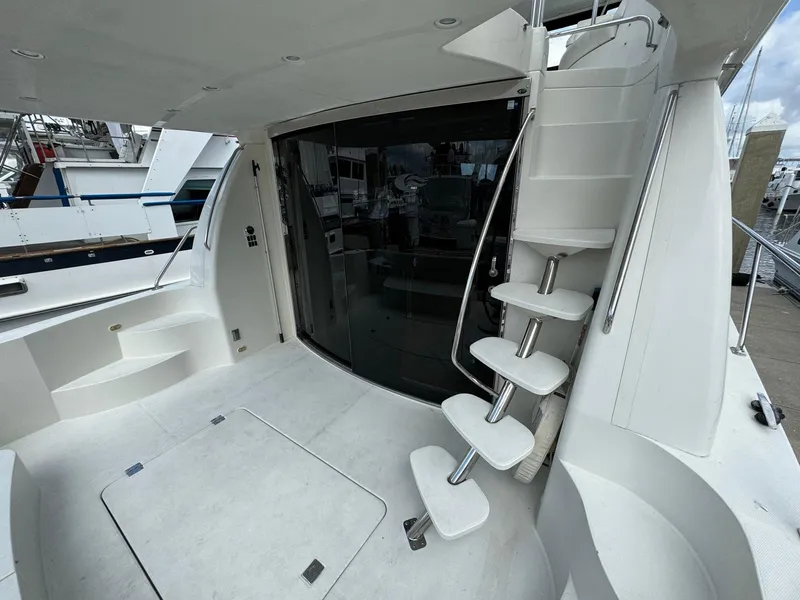 Slide: The Image of 2006 Carver 56 Voyager yacht with sleek white interior and spiral staircase. - 6