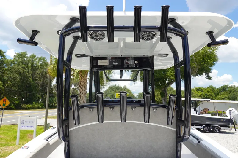 Slide: The Image of 2026 Sea Hunt Gamefish 30 boat with rod holders and T-top, parked outdoors. - 18