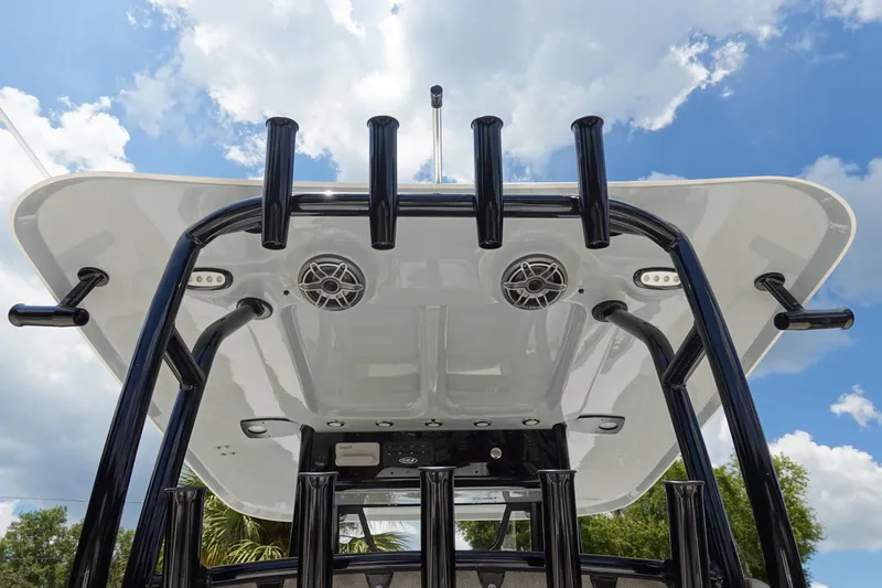 Slide: The Image of 2026 Sea Hunt Gamefish 30 boat with rod holders and speakers under a clear sky. - 19