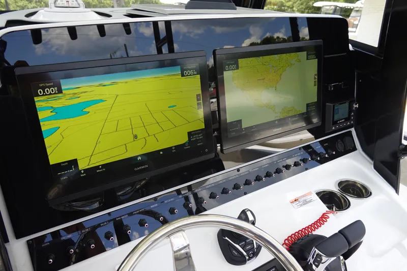 Slide: The Image of 2026 Sea Hunt Gamefish 30 dashboard with dual Garmin navigation screens and control panel. - 23