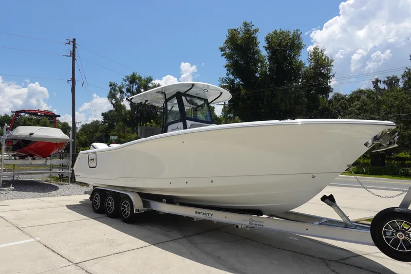 Slide: The Image of 2026 Sea Hunt Gamefish 30 Forward Seating boat on trailer, outdoors, sunny day. - 5
