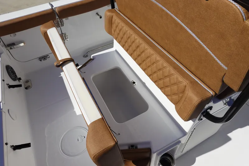 Slide: The Image of 2026 Sea Hunt Ultra 255 SE boat interior with brown cushioned seating and storage compartment. - 13