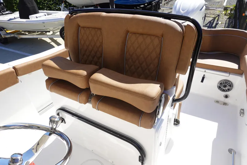 Slide: The Image of 2026 Sea Hunt Ultra 255 SE boat with tan cushioned seating and steering wheel. - 16