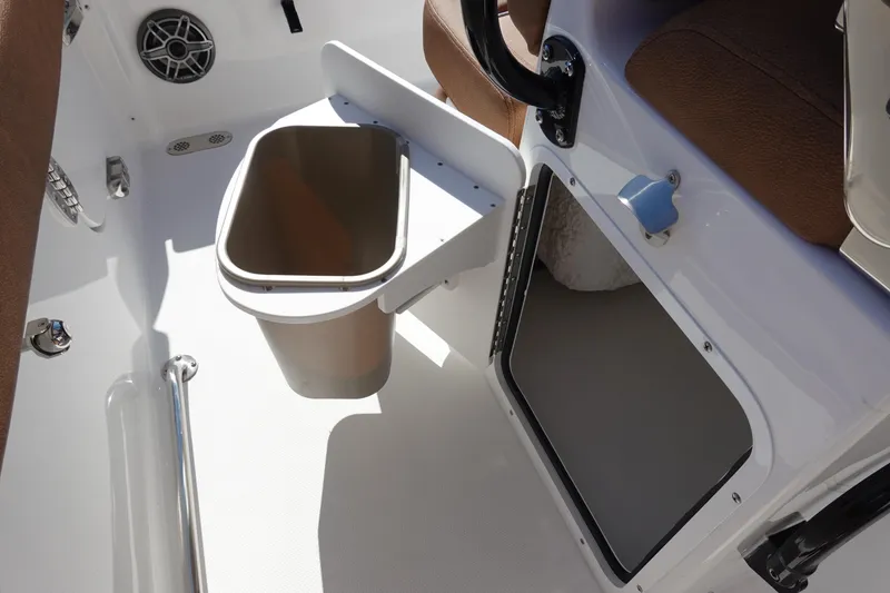 Slide: The Image of Interior of 2026 Sea Hunt Ultra 255 SE boat, featuring storage compartment and trash bin. - 19