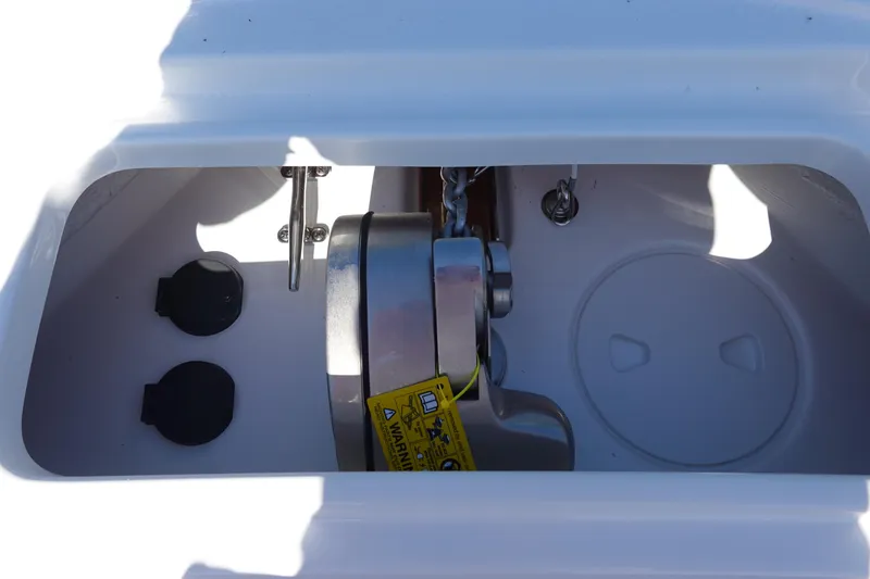 Slide: The Image of Anchor compartment of 2026 Sea Hunt Ultra 255 SE boat, featuring chain and cleat. - 31